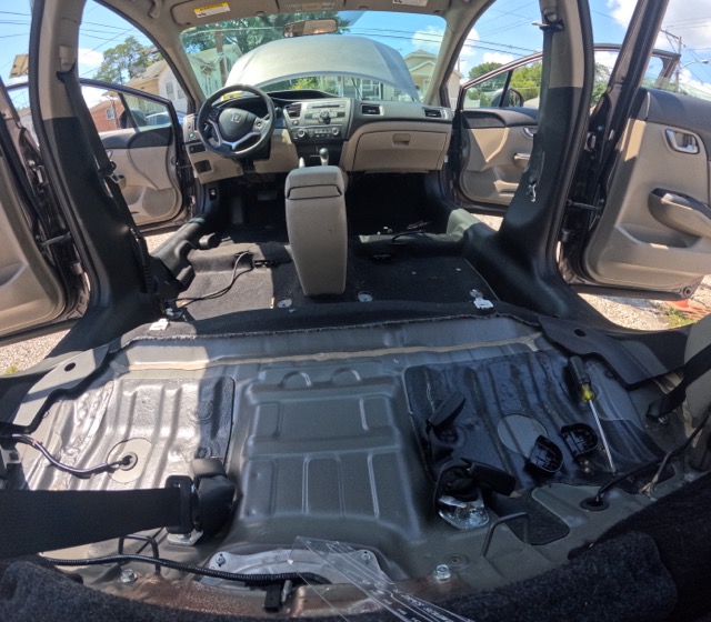 Vehicle interior during seat removal before deep mold and contamination cleaning